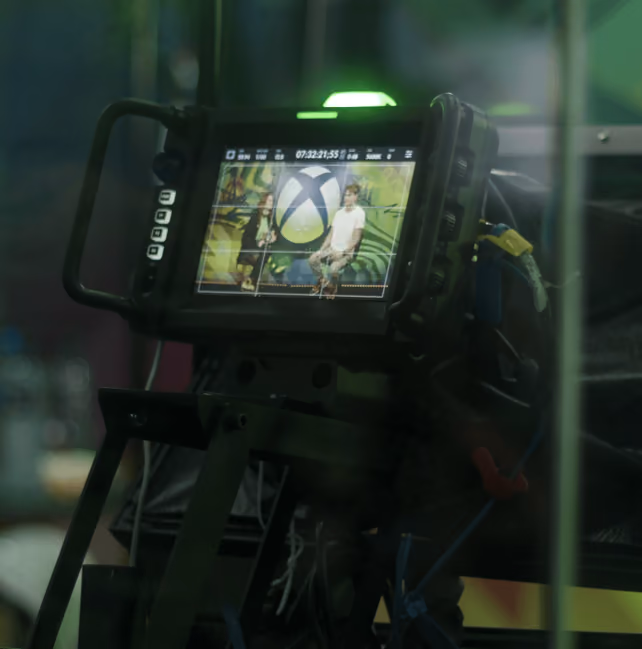Monitor de uma câmera de transmissão enquadrando um apresentador em um set de gravação.